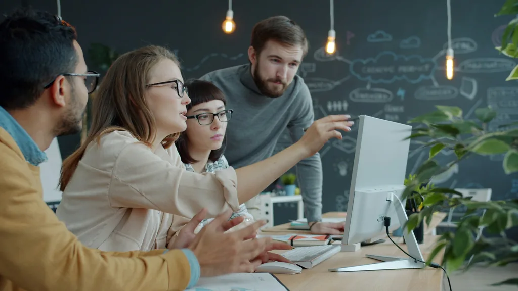 Team einer sozialen Einrichtung arbeitet gemeinsam an einem Laptop mit neuer Fachsoftware